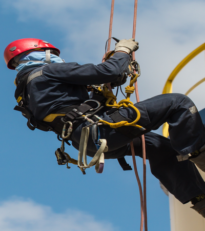 Tradesperson working at height with tools tethered by kevlar lanyard