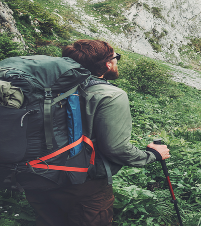 Coiled lanyard stretched to secure equipment to a rucksack outdoors